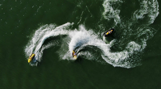 Jet skiiers turn circles on a lake, view from overhead